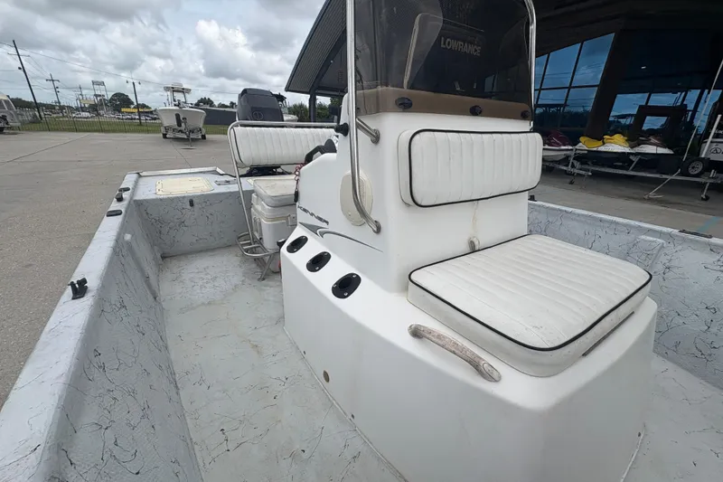 Slide: The Image of 2004 Kenner 18-V boat with white seating and Lowrance equipment, parked outdoors. - 16