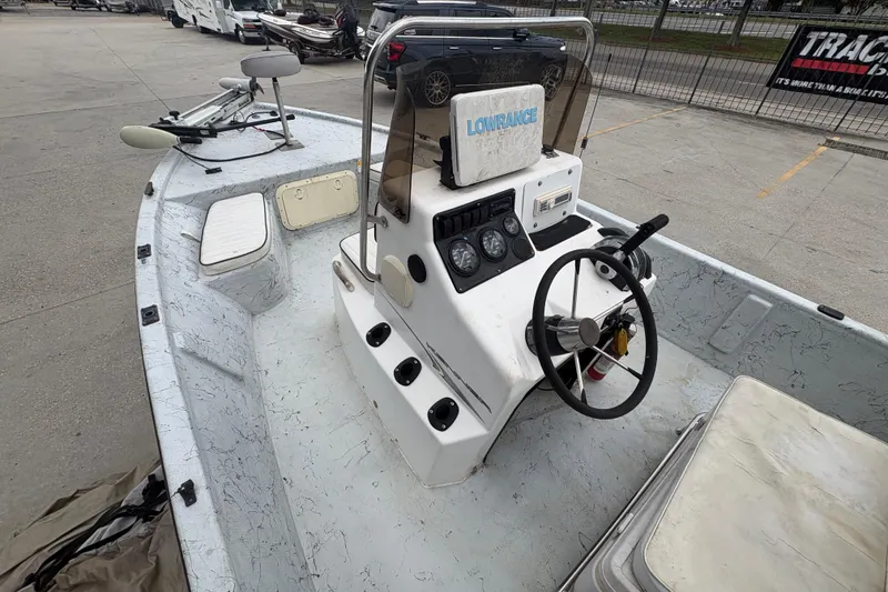 Slide: The Image of 2004 Kenner 18-V boat with steering console and Lowrance equipment, parked outdoors. - 21