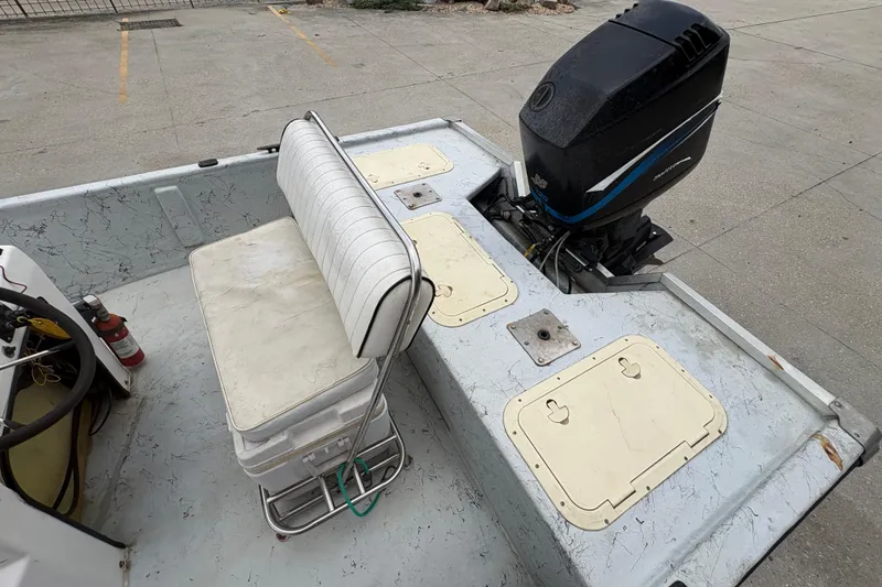 Slide: The Image of 2004 Kenner 18-V boat interior with seating and outboard motor. - 22