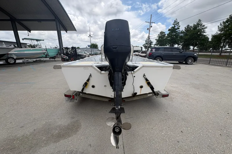 Slide: The Image of Rear view of a 2004 Kenner 18-V boat with an outboard motor in a parking lot. - 5
