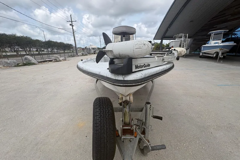 Slide: The Image of Kenner 18-V 2004 boat with MotorGuide trolling motor on trailer, parked outdoors. - 9