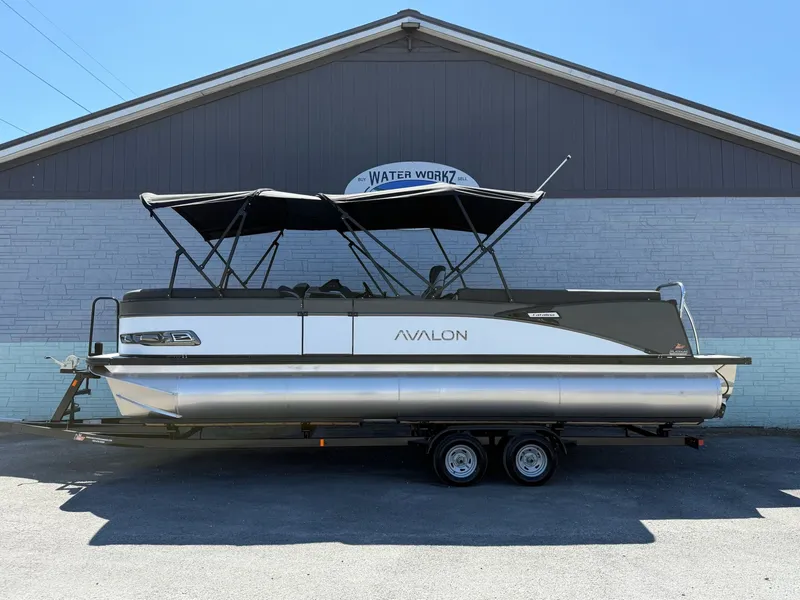 The Image of 2026 Avalon 2585 Catalina Quad Lounger pontoon boat in front of building. - 1