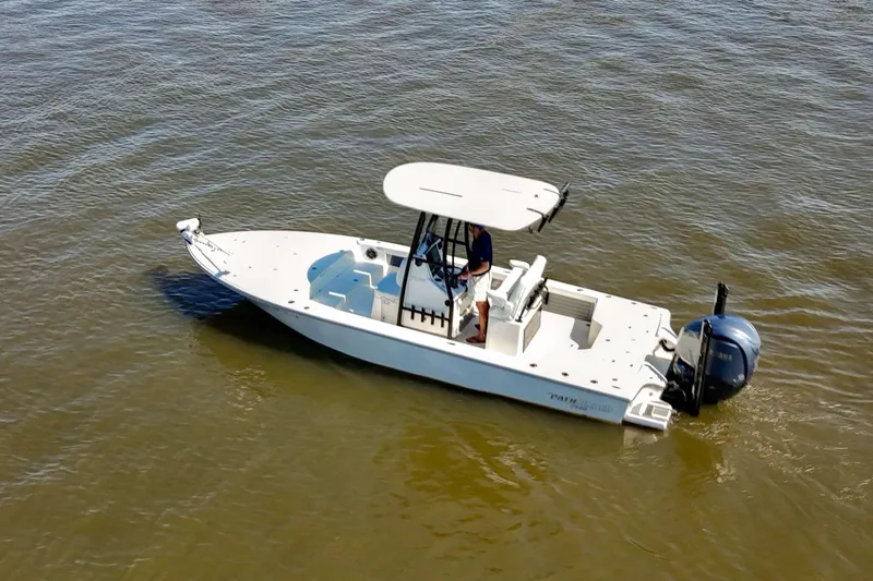 Slide: The Image of 2024 Pathfinder 2500 Hybrid boat on calm water, featuring a sleek design and outboard motor. - 1