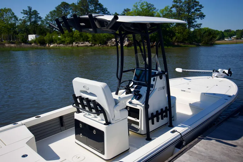 Slide: The Image of 2024 Pathfinder 2500 Hybrid boat docked on a serene lake. - 10