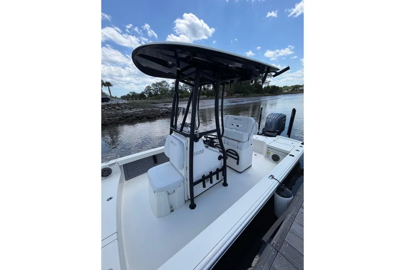 Slide: The Image of 2024 Pathfinder 2500 Hybrid boat docked by a scenic river under a blue sky. - 17