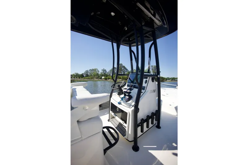 Slide: The Image of 2024 Pathfinder 2500 Hybrid boat console with steering wheel, on a sunny day by the water. - 18