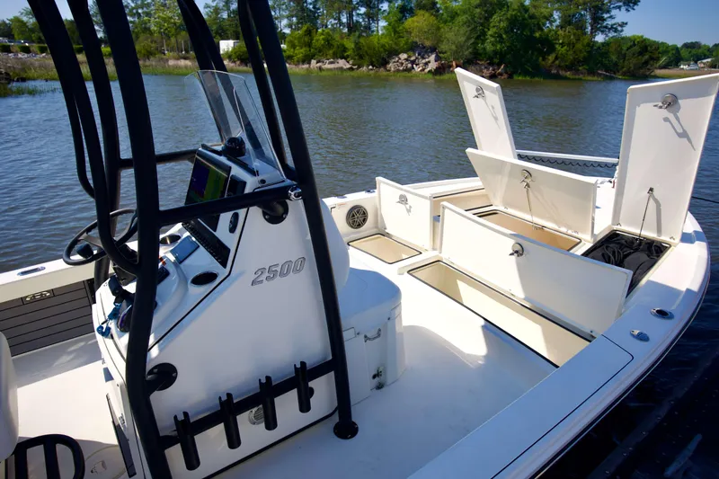 Slide: The Image of 2024 Pathfinder 2500 Hybrid boat interior with open storage compartments on a calm river. - 29