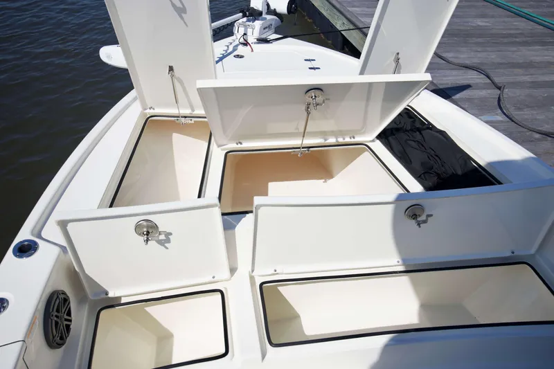 Slide: The Image of 2024 Pathfinder 2500 Hybrid boat with open storage compartments at the dock. - 30