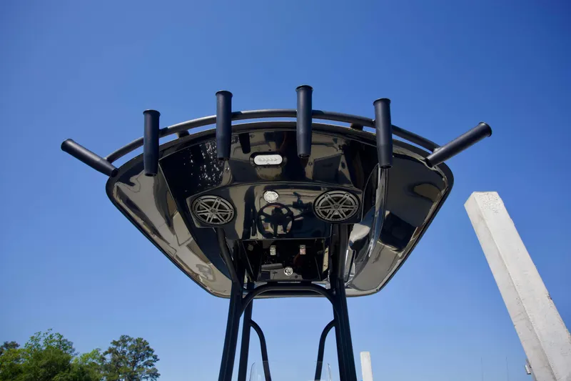 Slide: The Image of 2024 Pathfinder 2500 Hybrid boat canopy with rod holders and speakers against clear blue sky. - 34