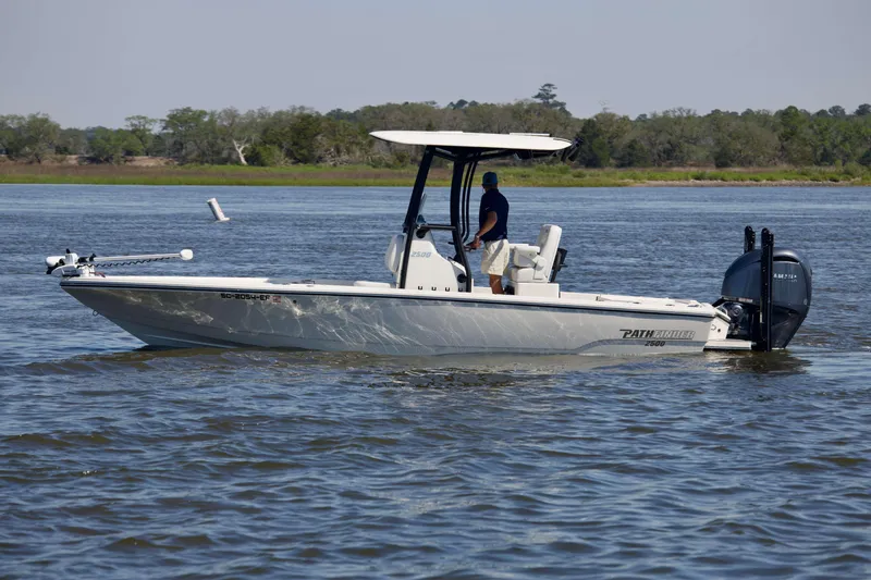 Slide: The Image of 2024 Pathfinder 2500 Hybrid boat cruising on a calm river with a person onboard. - 5