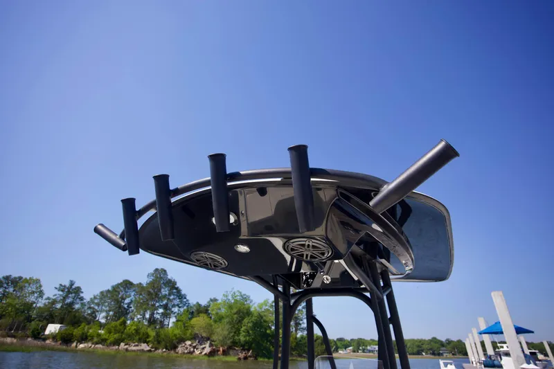 Slide: The Image of T-top of 2024 Pathfinder 2500 Hybrid boat with rod holders against clear blue sky. - 53