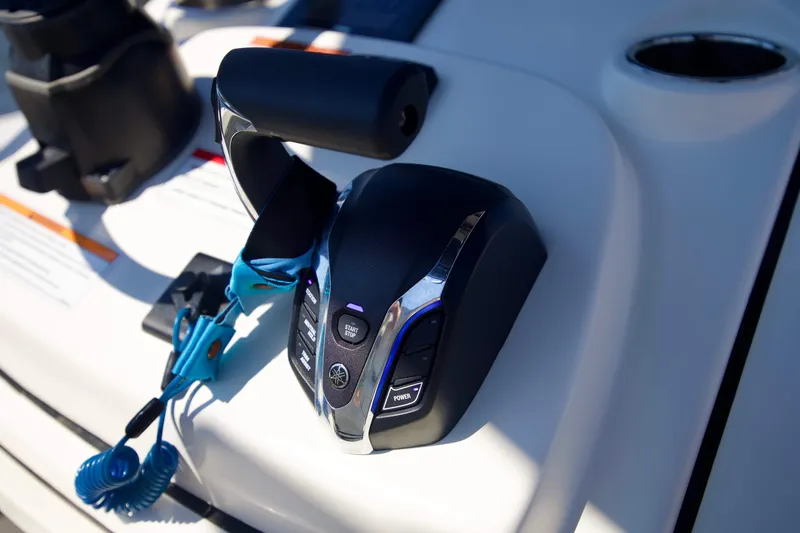 Slide: The Image of Close-up of 2024 Pathfinder 2500 Hybrid boat throttle control with blue safety lanyard. - 58