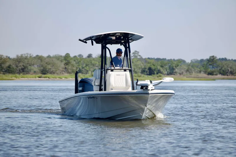 Slide: The Image of 2024 Pathfinder 2500 Hybrid boat cruising on a calm river with lush greenery. - 6