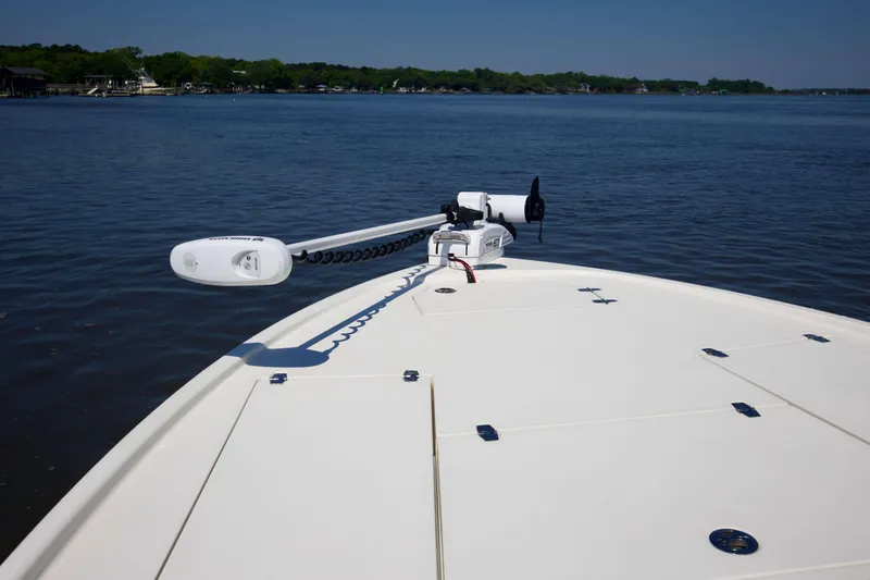 Slide: The Image of 2024 Pathfinder 2500 Hybrid boat on calm water, featuring a sleek deck design. - 61