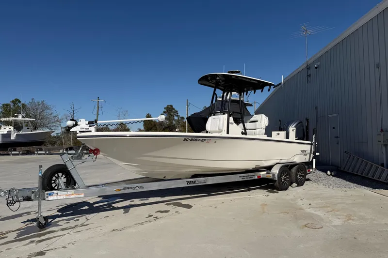 Slide: The Image of 2024 Pathfinder 2500 Hybrid boat on trailer, parked outdoors near a building. - 77