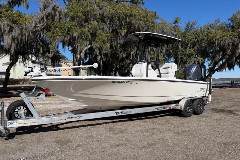 Slide: The Image of 2024 Pathfinder 2500 Hybrid boat on trailer, parked outdoors under trees. - 8