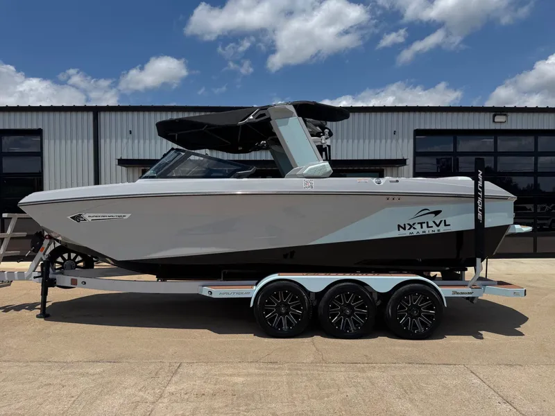 The Image of 2023 Nautique G23 boat on trailer in front of warehouse. - 1