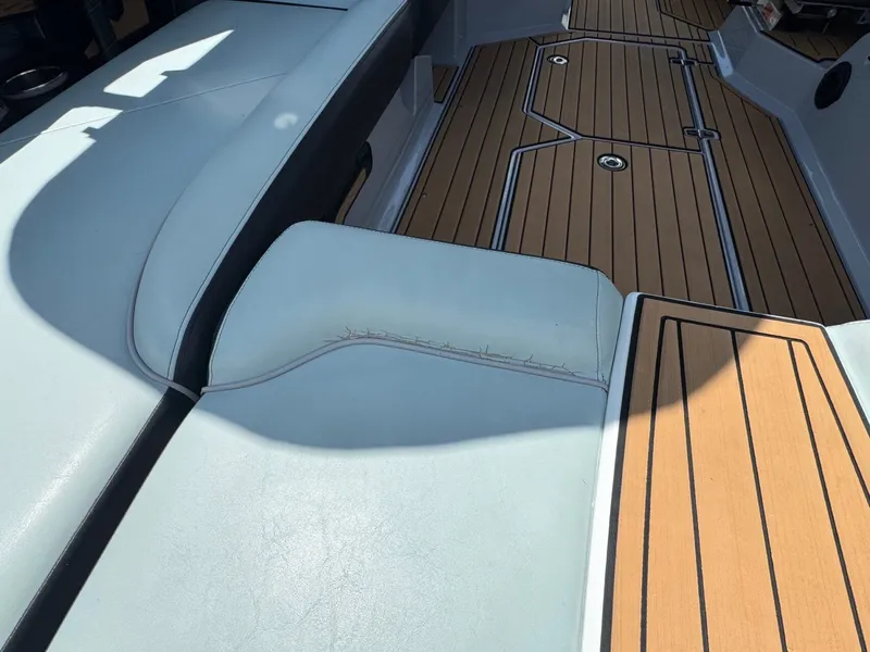 Slide: The Image of Interior of 2023 Nautique G23 with wooden flooring and white seating. - 14