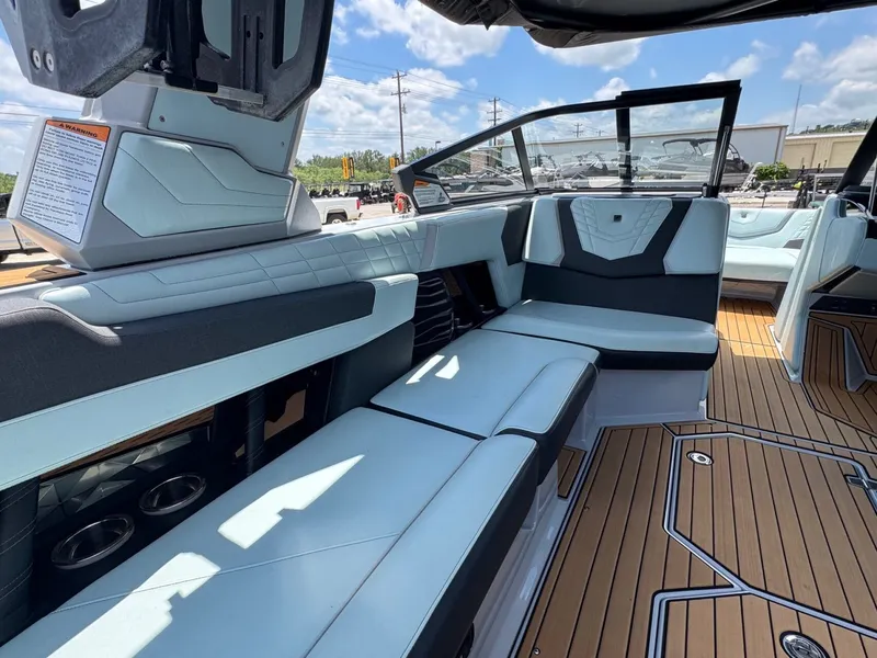 Slide: The Image of 2023 Nautique G23 interior with luxurious seating and wood flooring. - 16