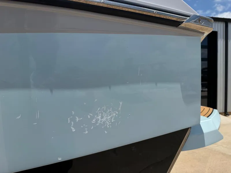 Slide: The Image of Close-up of 2023 Nautique G23 boat with scratches on the hull. - 4