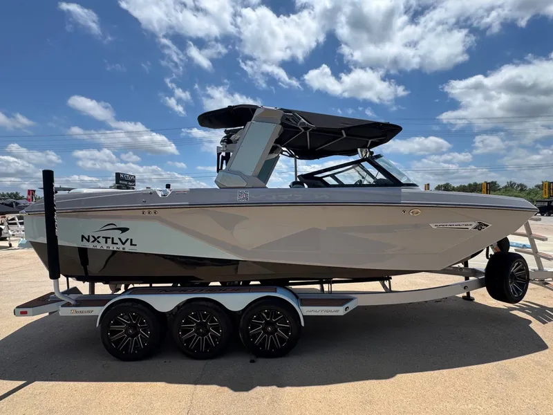 Slide: The Image of 2023 Nautique G23 boat on trailer under blue sky. - 8