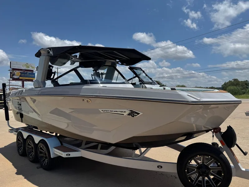 Slide: The Image of 2023 Nautique G23 boat on trailer under blue sky. - 9