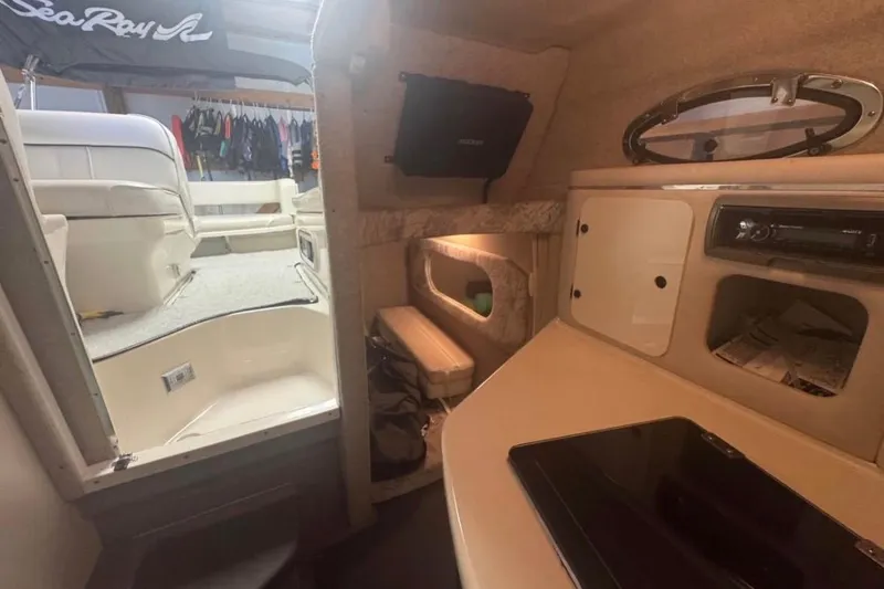 Slide: The Image of Interior view of a 1995 Sea Ray 250 Sundancer cabin with seating and storage. - 10