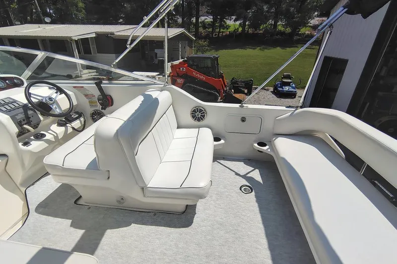 Slide: The Image of 1995 Sea Ray 250 Sundancer boat interior with white seating and steering wheel. - 5