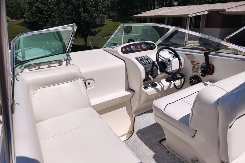 Slide: The Image of 1995 Sea Ray 250 Sundancer boat interior with white seating and control panel. - 6
