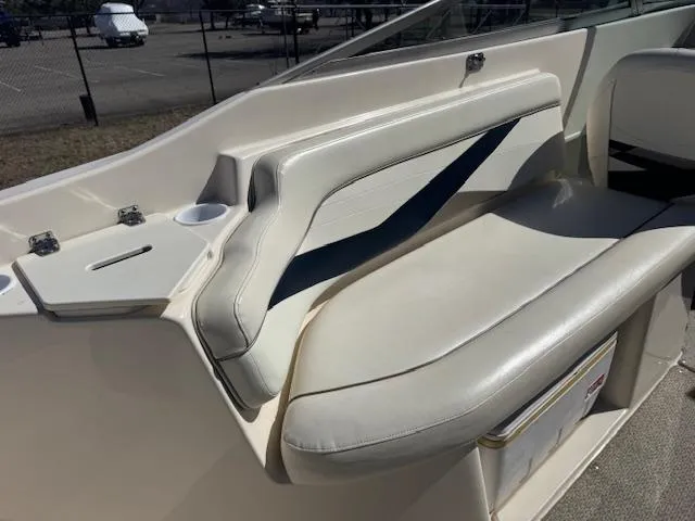 Slide: The Image of 2003 Rinker 282 Captiva Cuddy boat interior with white seating and cup holder. - 10