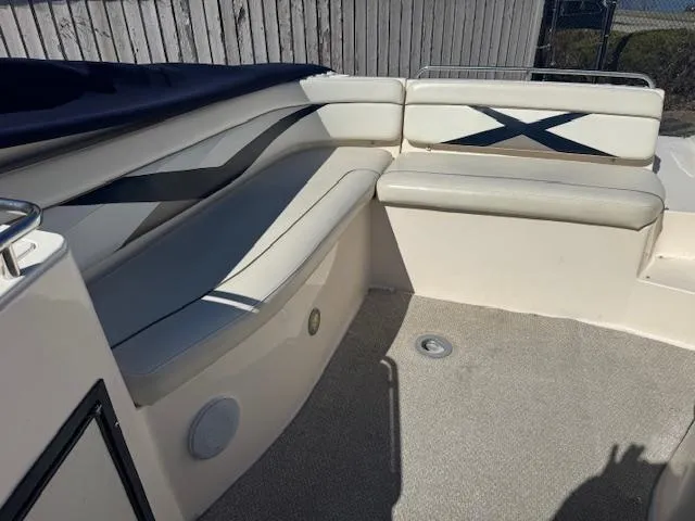 Slide: The Image of 2003 Rinker 282 Captiva Cuddy interior with cushioned seating and carpeted floor. - 12