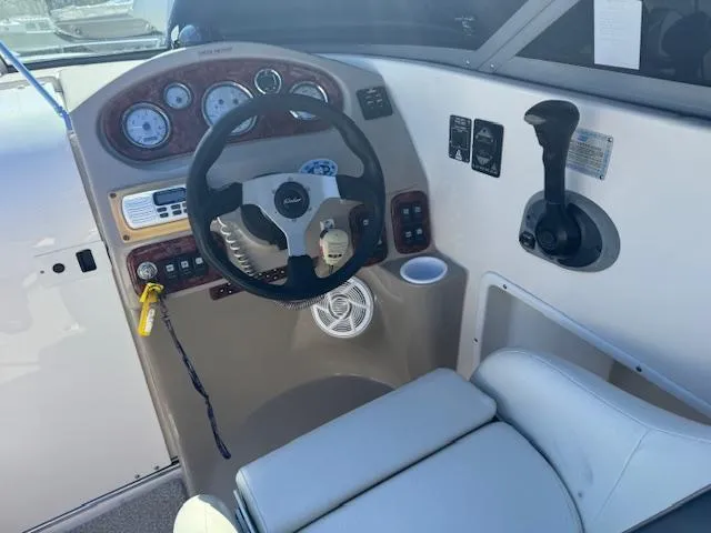 Slide: The Image of 2003 Rinker 282 Captiva Cuddy boat cockpit with steering wheel and control panel. - 14