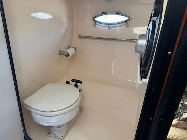Slide: The Image of 2003 Rinker 282 Captiva Cuddy boat bathroom with toilet and porthole window. - 20
