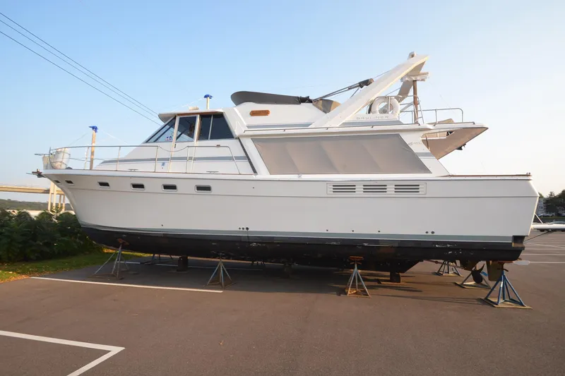 The Image of 1989 Bayliner 4518 Motoryacht on stands in a parking lot, side view. - 0