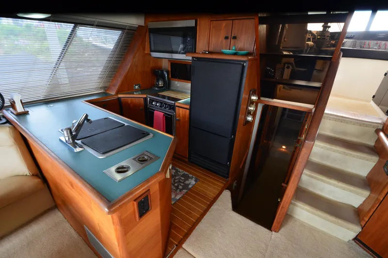 Slide: The Image of Interior of 1989 Bayliner 4518 Motoryacht featuring kitchen area with stove and sink. - 13