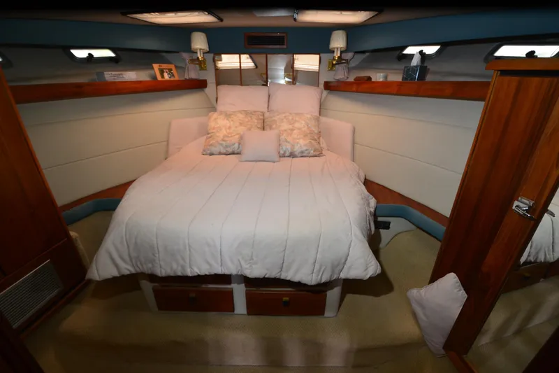 Slide: The Image of Cozy bedroom interior of 1989 Bayliner 4518 Motoryacht with plush bedding and wooden accents. - 19
