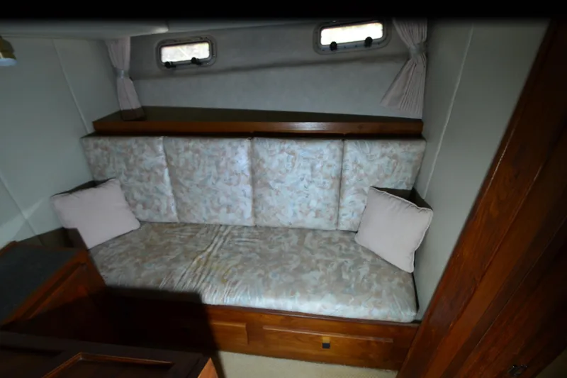 Slide: The Image of Interior of 1989 Bayliner 4518 Motoryacht with cushioned seating and wooden accents. - 24