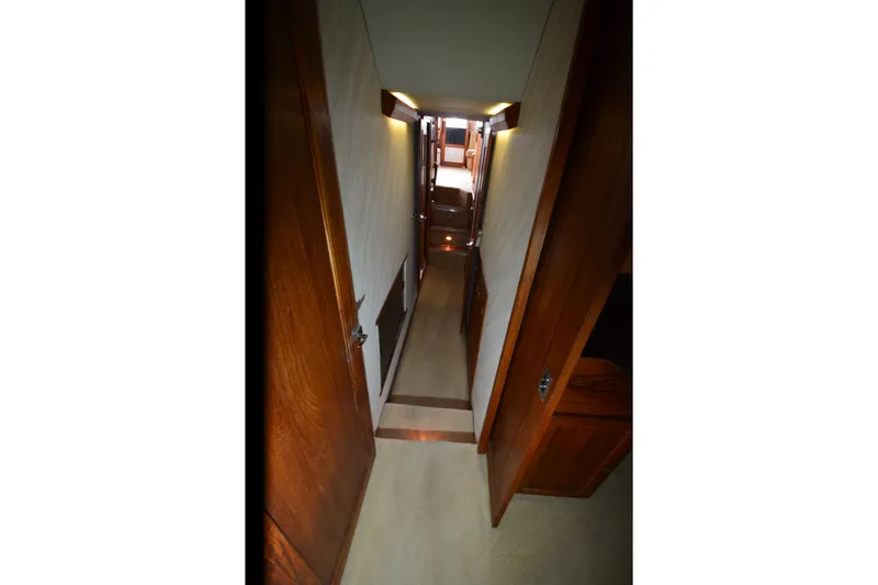 Slide: The Image of Narrow hallway inside 1989 Bayliner 4518 Motoryacht, featuring wooden doors and soft lighting. - 25