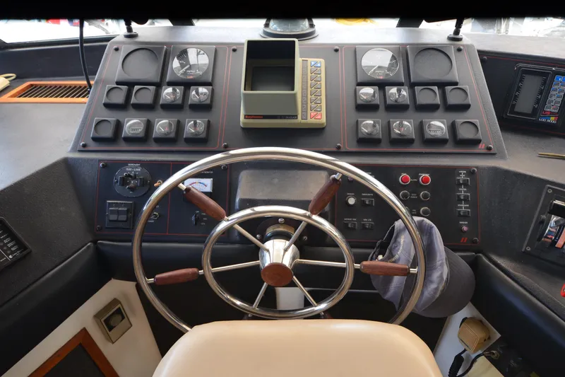 Slide: The Image of 1989 Bayliner 4518 Motoryacht helm with steering wheel and control panels. - 32