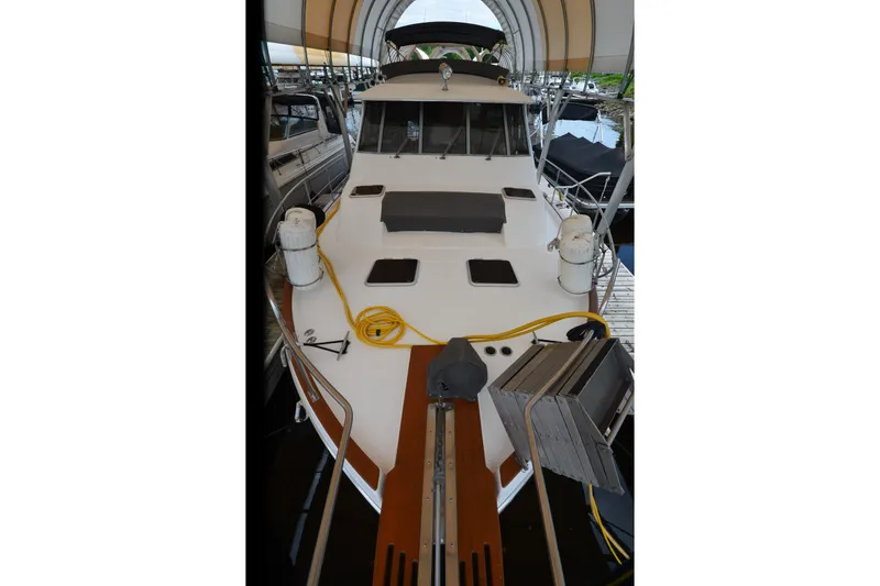 Slide: The Image of 1989 Bayliner 4518 Motoryacht docked under a canopy, showcasing its spacious deck. - 39