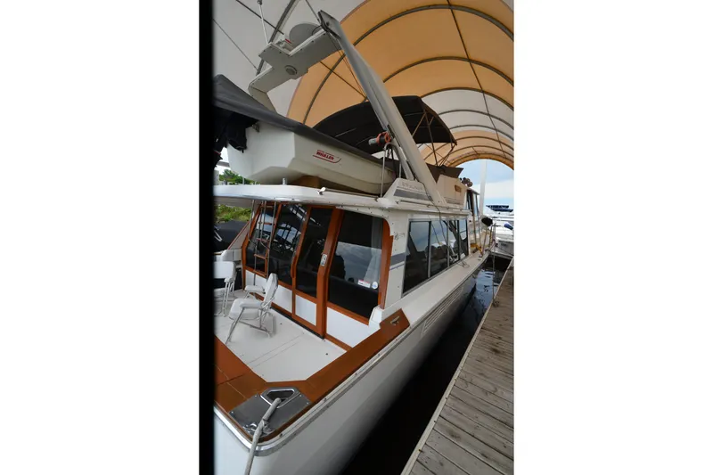 Slide: The Image of 1989 Bayliner 4518 Motoryacht docked under canopy, showcasing sleek design and spacious deck. - 5