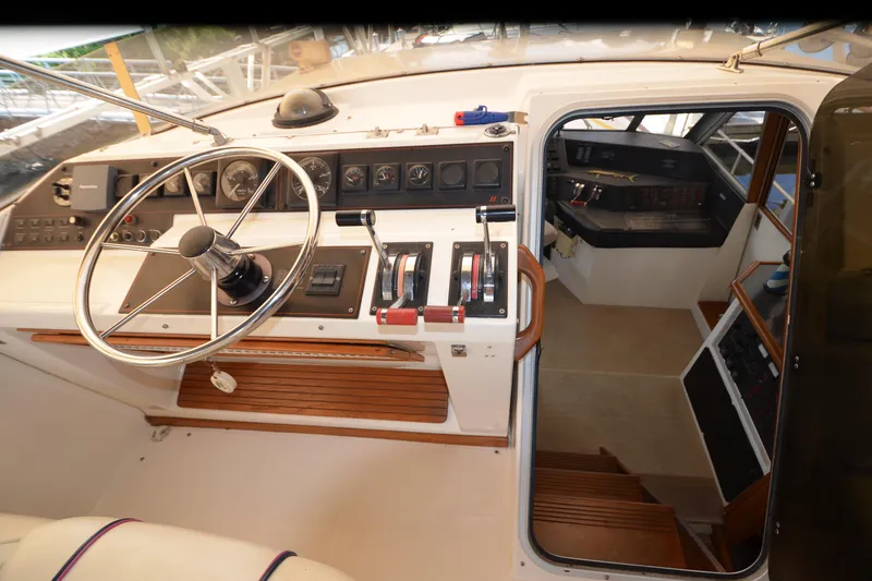 Slide: The Image of 1989 Bayliner 4518 Motoryacht helm with steering wheel and control panel. - 50