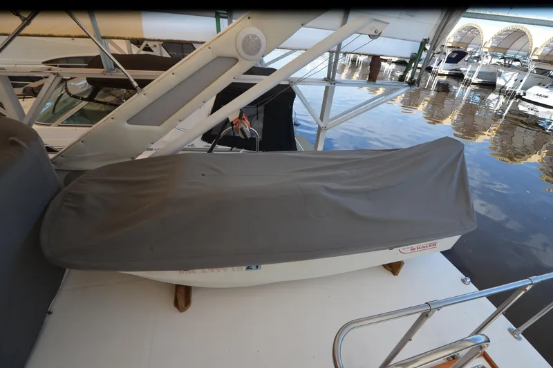 Slide: The Image of 1989 Bayliner 4518 Motoryacht with covered dinghy on deck, docked at marina. - 52