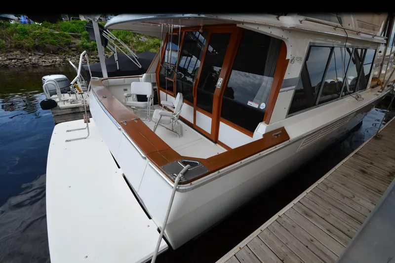Slide: The Image of 1989 Bayliner 4518 Motoryacht docked, featuring spacious deck and wooden accents. - 6