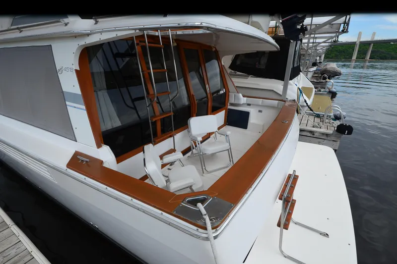 Slide: The Image of 1989 Bayliner 4518 Motoryacht docked, featuring spacious deck and seating area. - 7