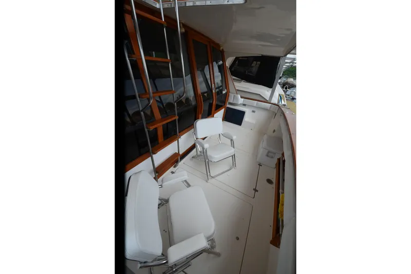 Slide: The Image of 1989 Bayliner 4518 Motoryacht deck with white seating and wooden accents. - 9