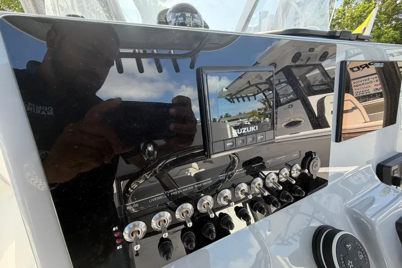 Slide: The Image of 2026 Sea Pro 225FLX Sandbar boat dashboard with Suzuki controls and switches. - 23