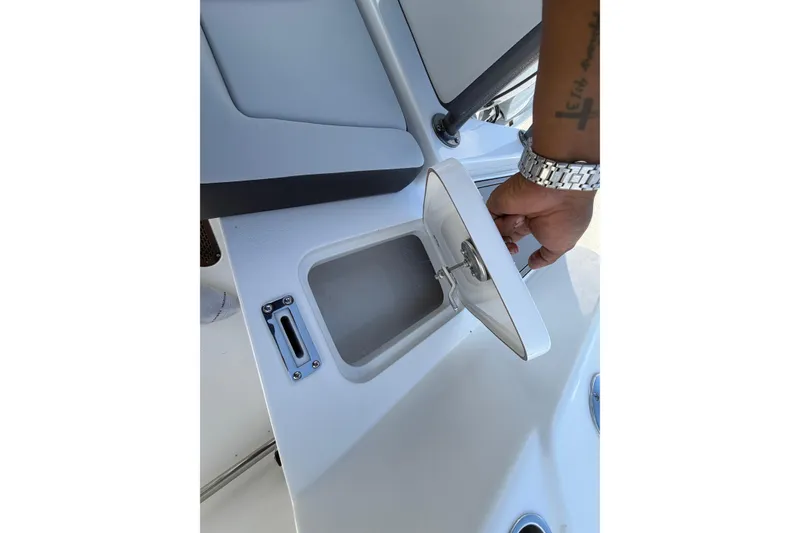 Slide: The Image of 2026 Sea Pro 225FLX Sandbar boat compartment being opened by a hand. - 34
