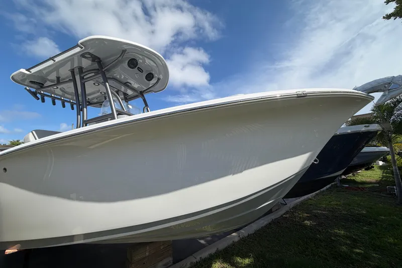 Slide: The Image of 2026 Sea Pro 225FLX Sandbar boat with T-top, displayed outdoors under blue sky. - 6