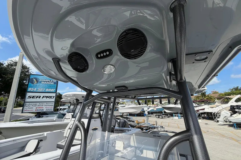 Slide: The Image of 2026 Sea Pro 225FLX Sandbar boat interior with speakers and marina background. - 7